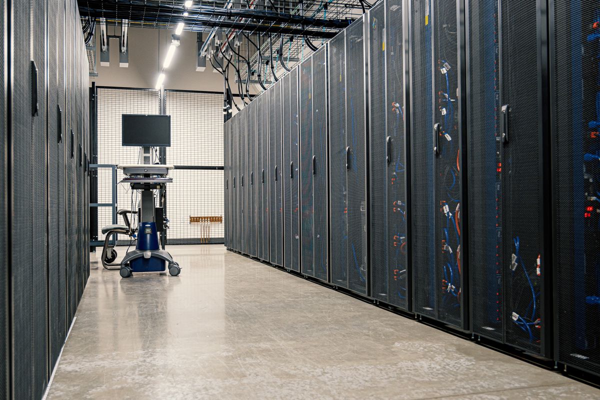 Phòng máy chủ với dãy rack và xe đẩy màn hình, minh họa hạ tầng tự chạy AI on-premise