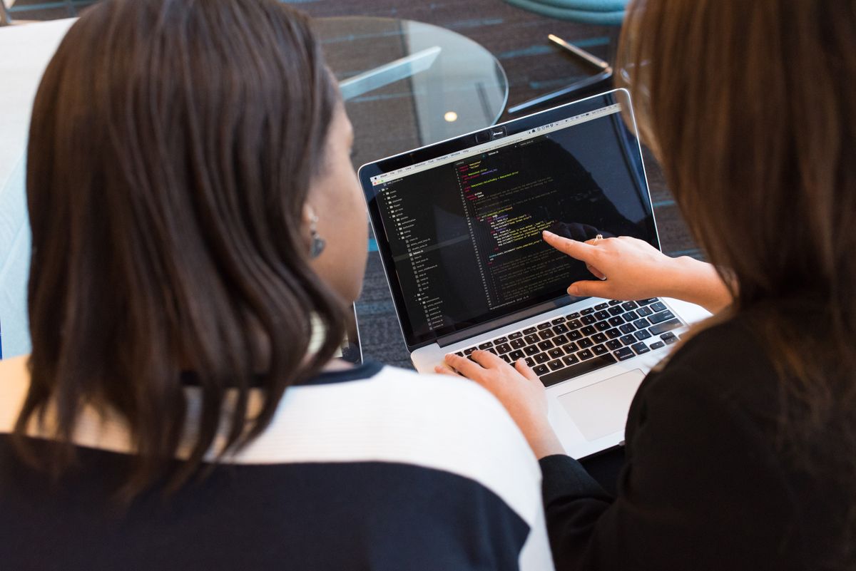 Hai lập trình viên cùng làm việc trên màn hình code