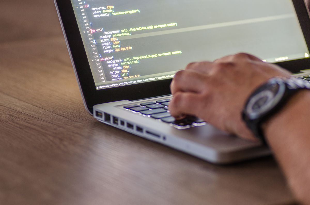 Bàn tay developer gõ code trên laptop
