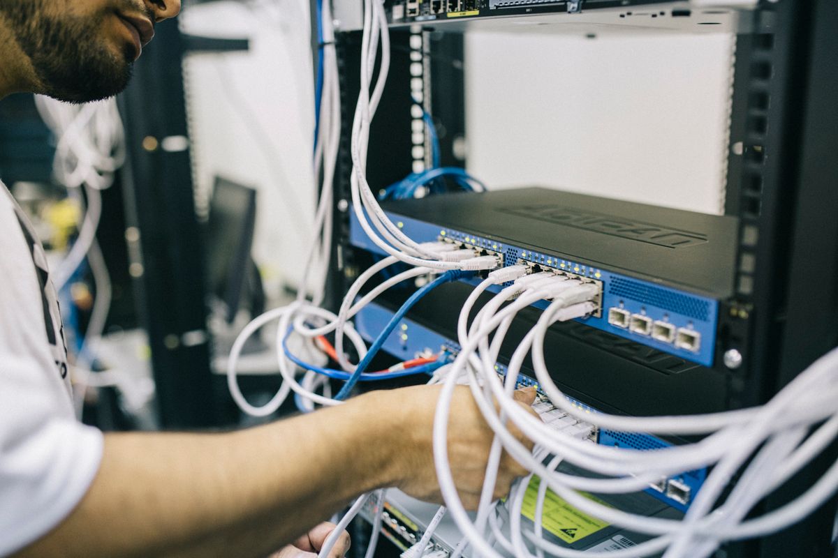 Kỹ sư đấu nối cáp mạng vào thiết bị trong tủ rack