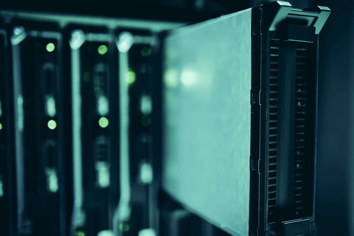 Close-up of blade servers seated in a rack chassis with green status lights, tinted teal