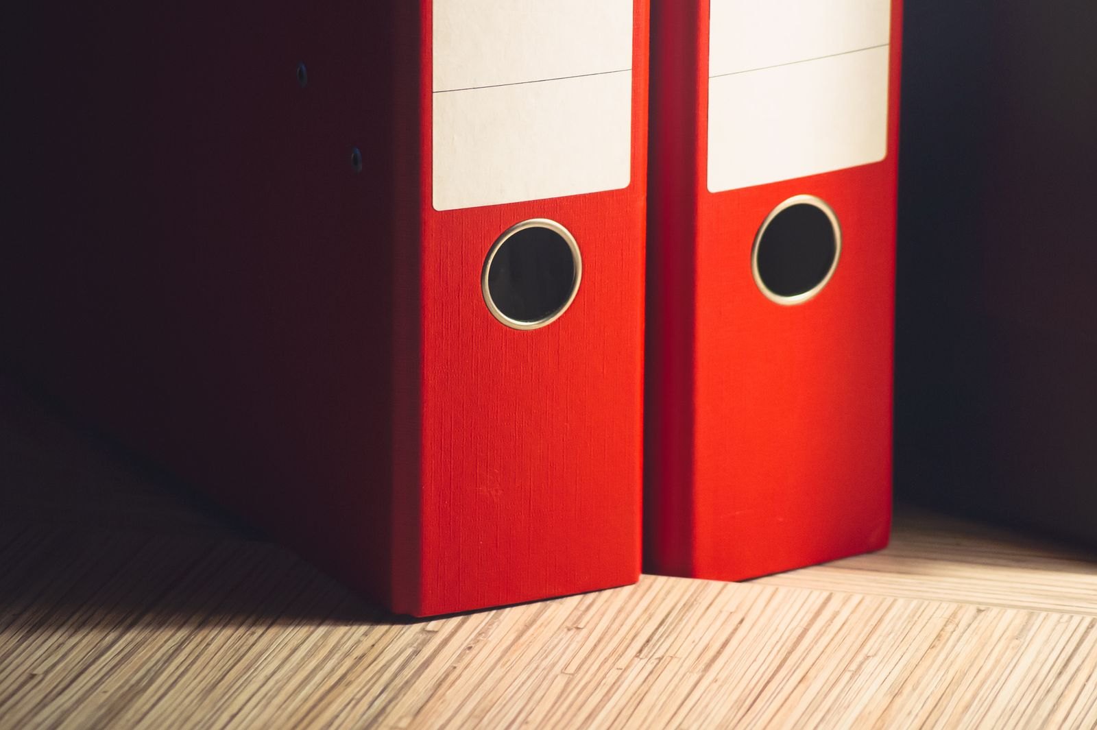 Two red lever-arch files, where company knowledge often sits scattered on paper